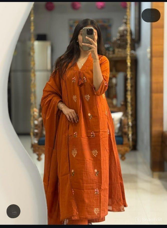 Person wearing an orange embroidered dress taking a mirror selfie.