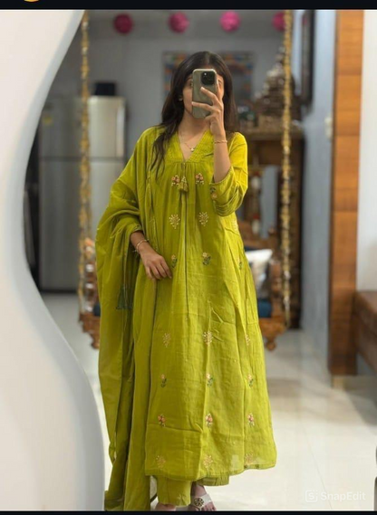 Person wearing a green traditional outfit taking a mirror selfie.