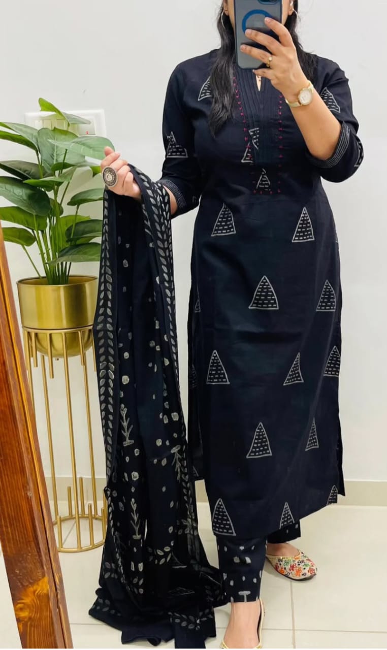 Person wearing a dark blue traditional outfit with geometric patterns, holding a matching dupatta.