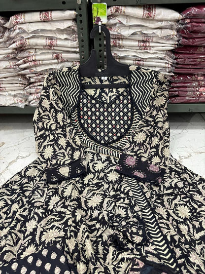 Black and white patterned dress on a hanger with bags in the background