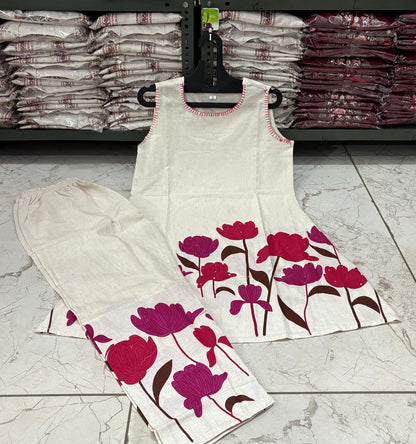 Floral-patterned fabric on a hanger with stacks of fabric in the background.