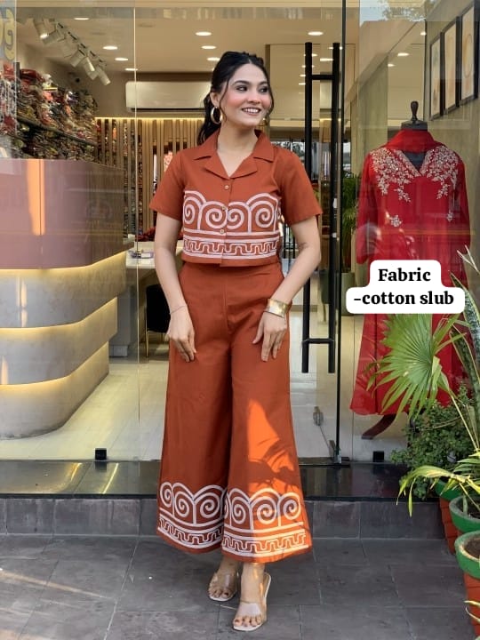 Woman wearing a brown outfit with white patterns in a store setting