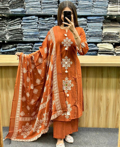 A woman wearing an orange embroidered outfit in a fabric store.