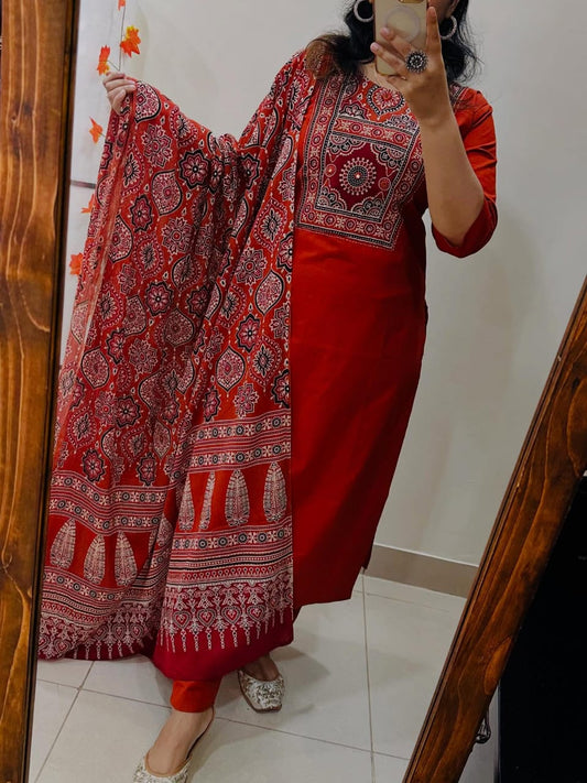 Person wearing a red traditional outfit with a patterned dupatta, taking a mirror selfie.