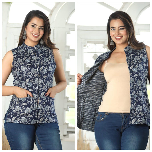 Woman wearing a navy floral vest over a beige top and blue jeans, with a white decorative background.