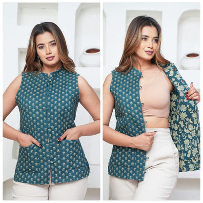 Woman wearing a green floral sleeveless jacket with white pants against a neutral background