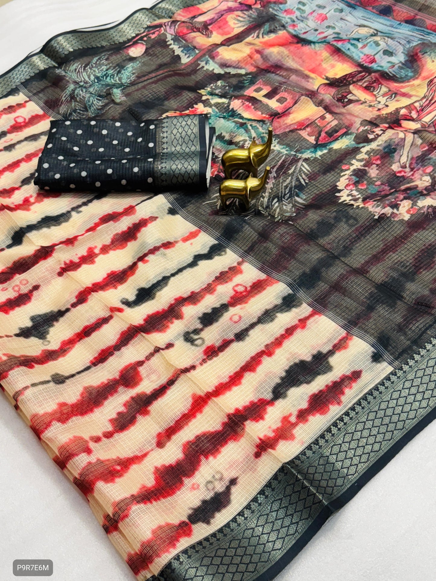 Colorful patterned fabric with a black pouch and gold bangles on a white background