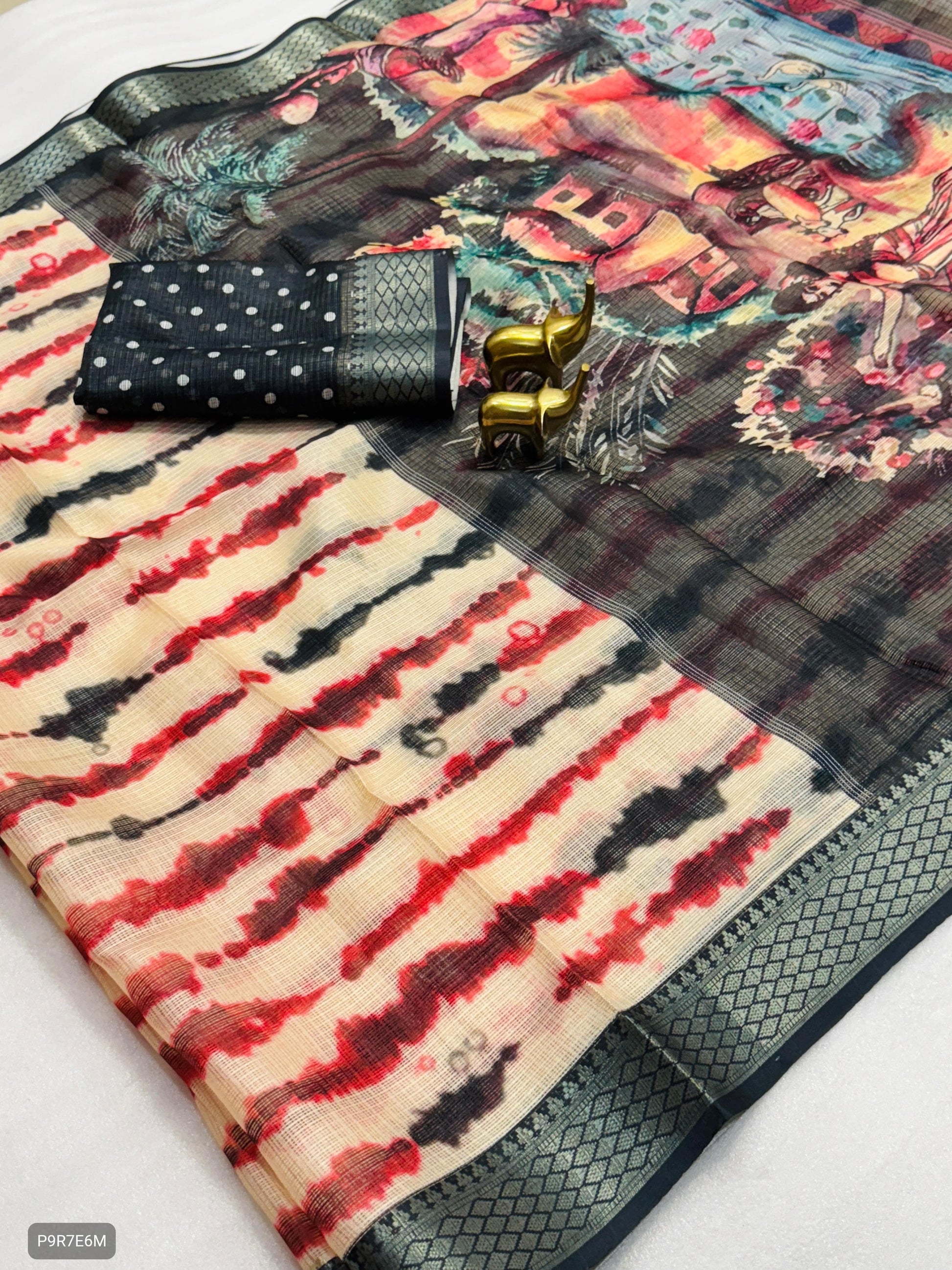 Colorful patterned fabric with a black pouch and gold bangles on a white background