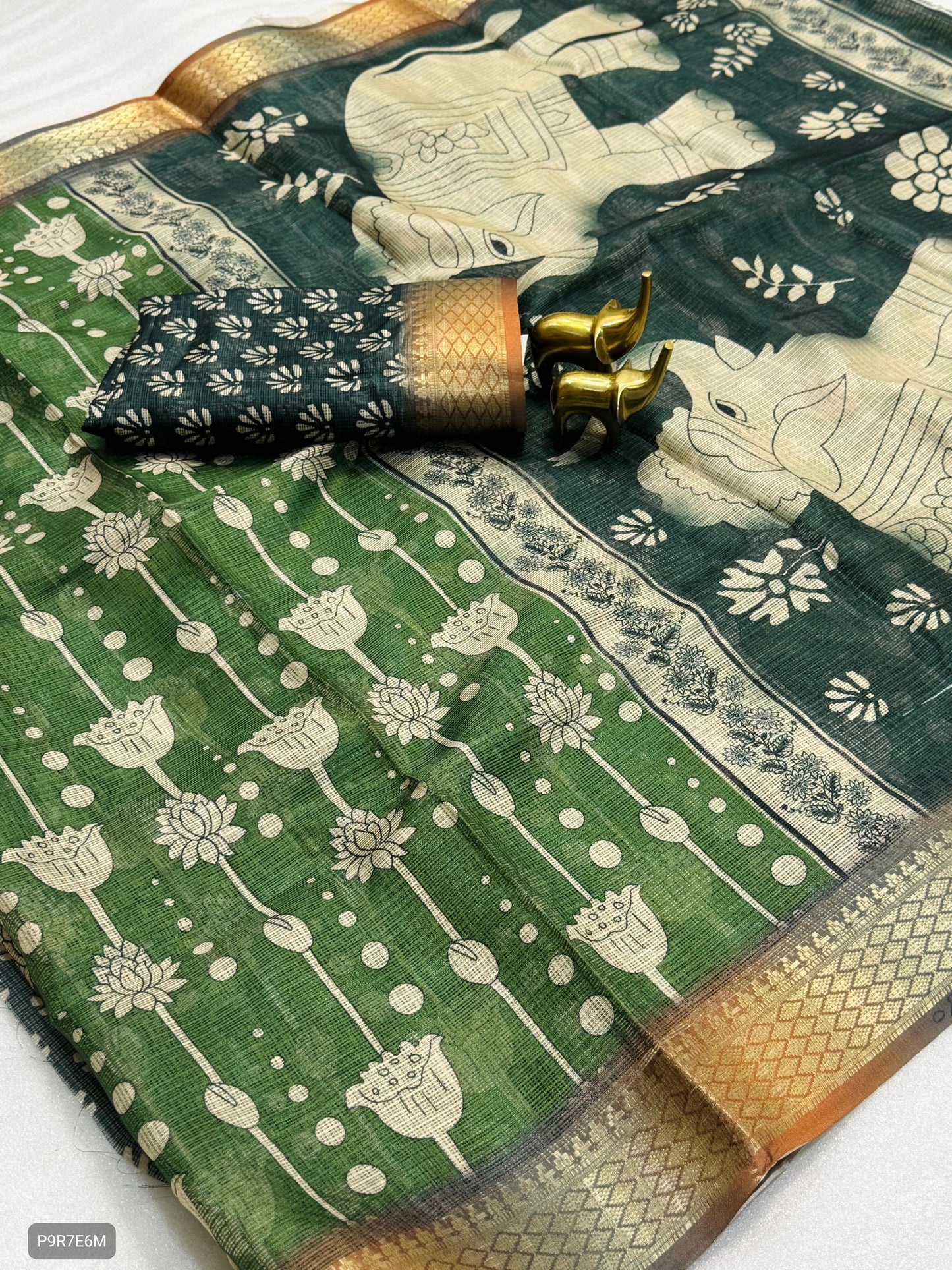Green and gold traditional fabric with elephant design on a white background