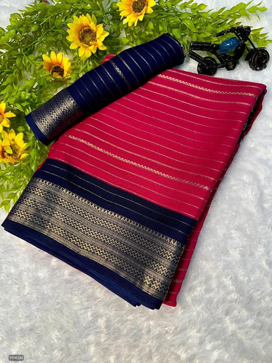 Folded red and blue fabric with decorative patterns on a white surface with green leaves and sunflowers.
