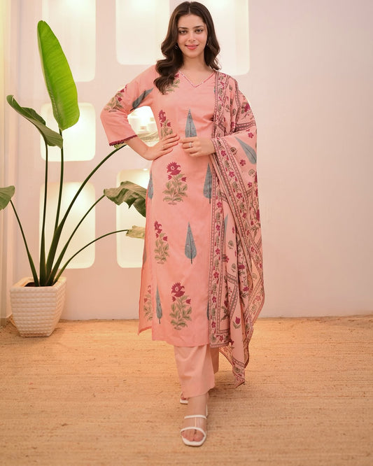 Woman wearing a pink traditional outfit with floral patterns in a well-lit room.