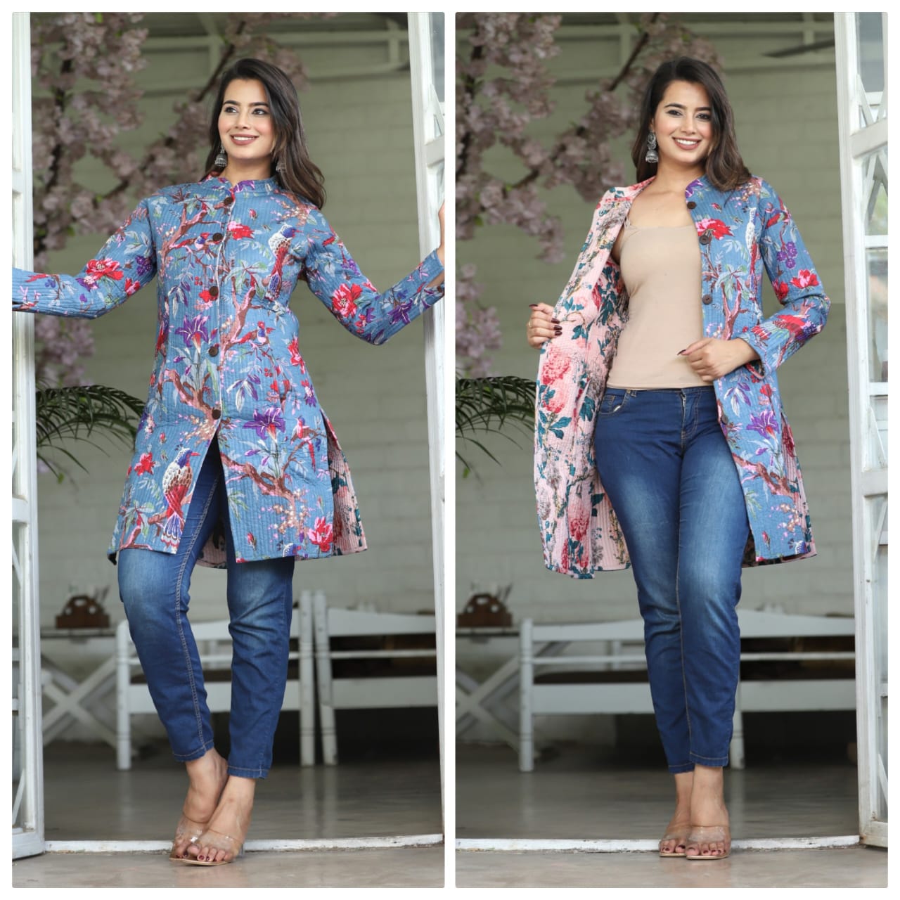 Woman wearing a floral coat over a beige top and blue jeans, standing in front of a white door with cherry blossom branches.