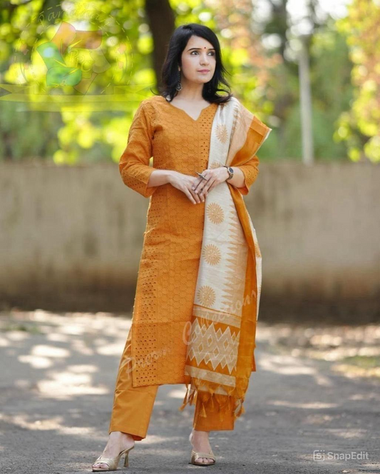Woman wearing a mustard yellow traditional outfit with a white dupatta in an outdoor setting.
